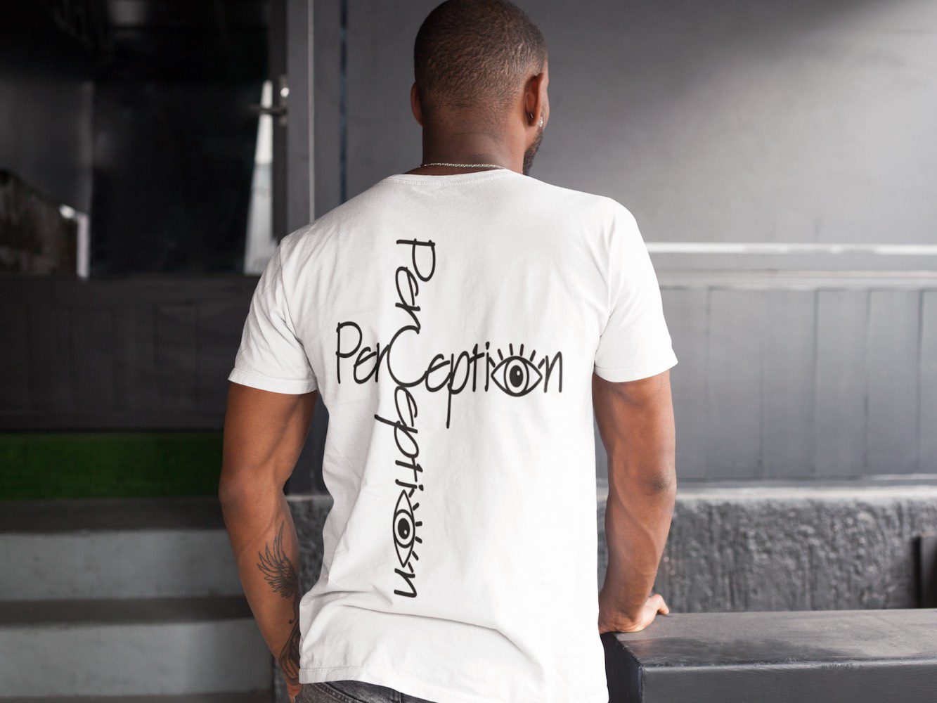 A man wearing a white shirt with the word " perception " on it.