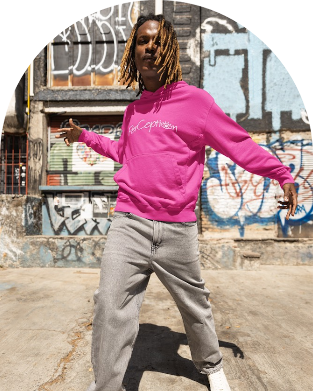 A man in pink sweatshirt and gray pants riding on a skateboard.