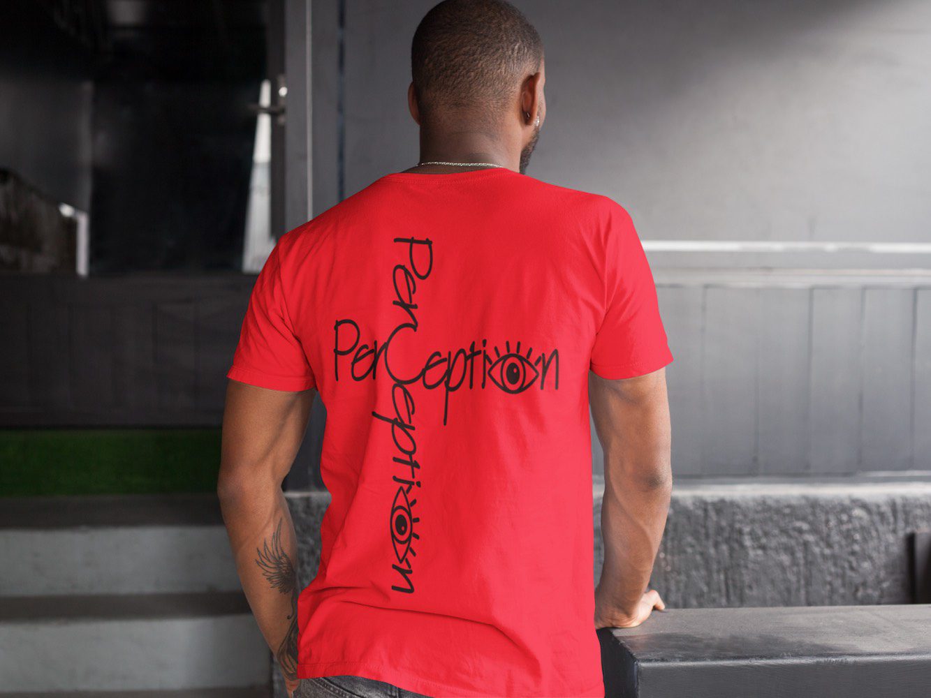 A man wearing a red shirt with black writing on it.