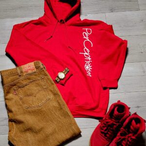 A red hoodie and brown shorts are on the floor.